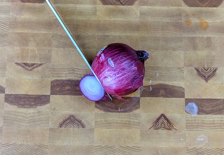 slicing the end off of a red onion