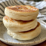 A stack of three homemade sourdough english muffins